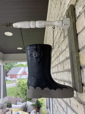 Black rain boot hanging on porch bracket