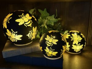 Three glowing bee-patterned orb lamps