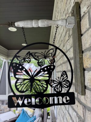 Decorative butterfly welcome sign hanging on porch
