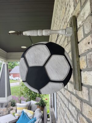 Decorative hanging soccer ball sign on porch